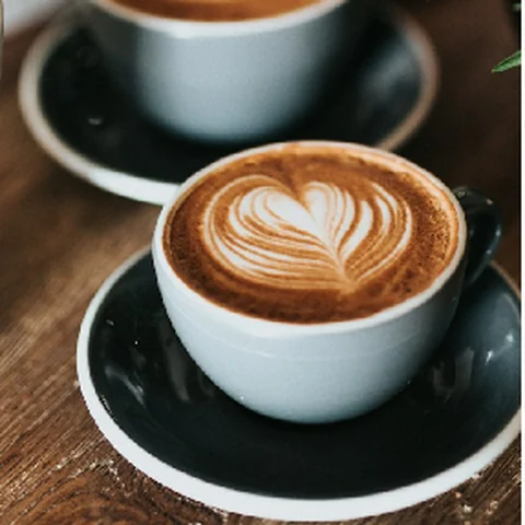 Two cups of latte on a wooden table